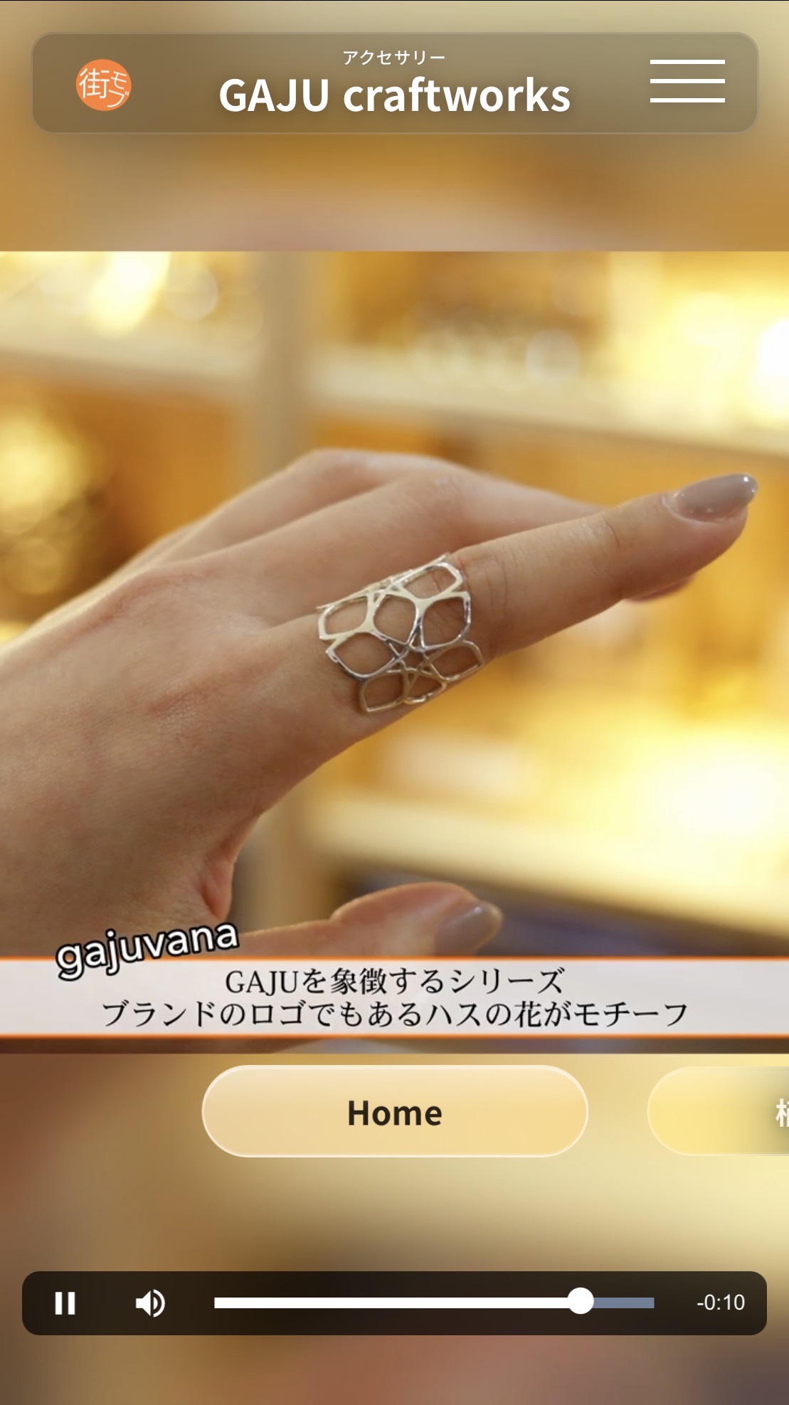 GAJU craftworks様の街モブ画面。アクセサリーの紹介動画、字幕、Homeボタン、再生操作が表示されています。