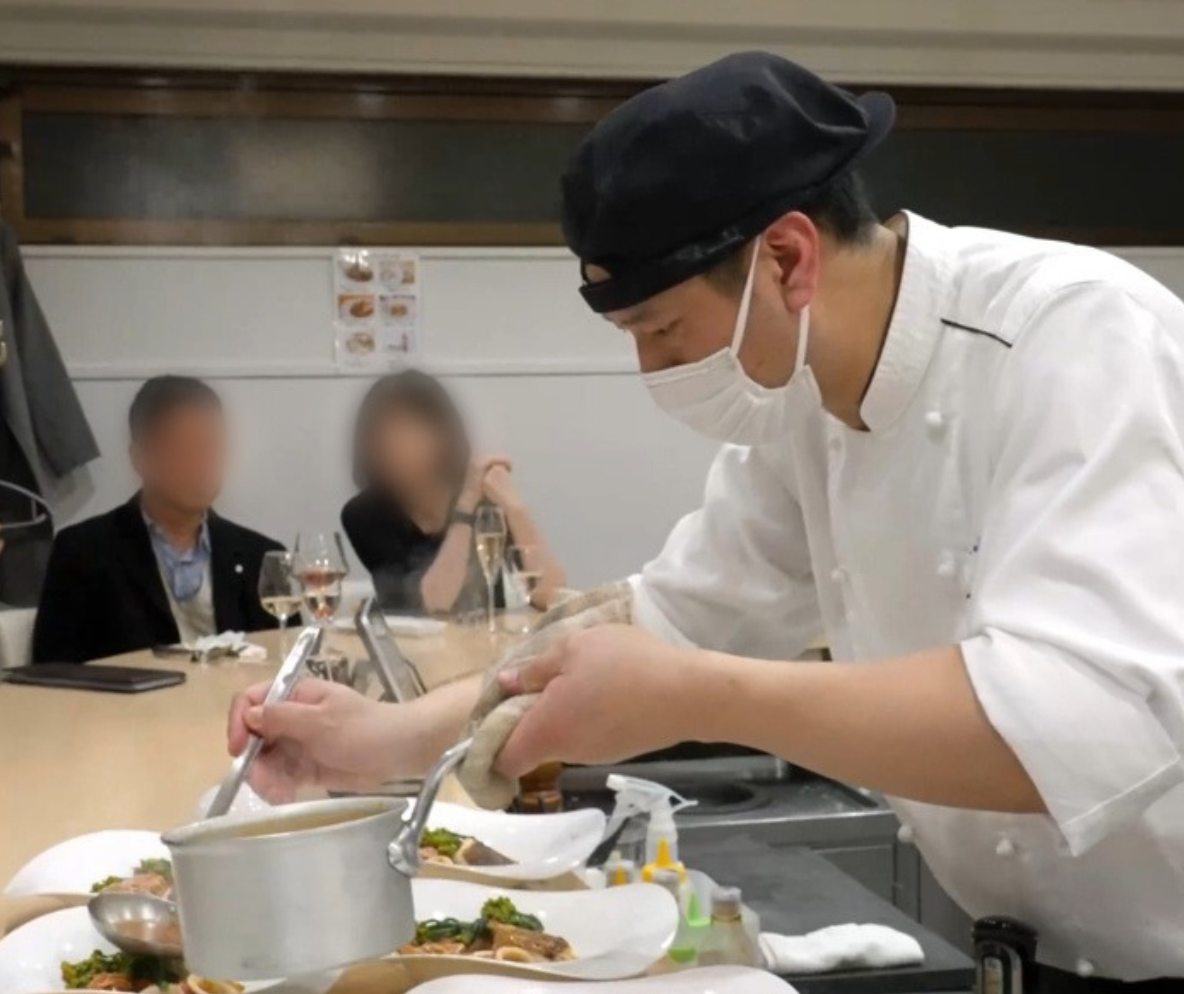 料理の仕上げに集中する料理人